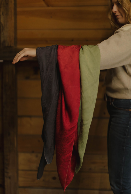 Woman with 3 silk scarved draped over her arm